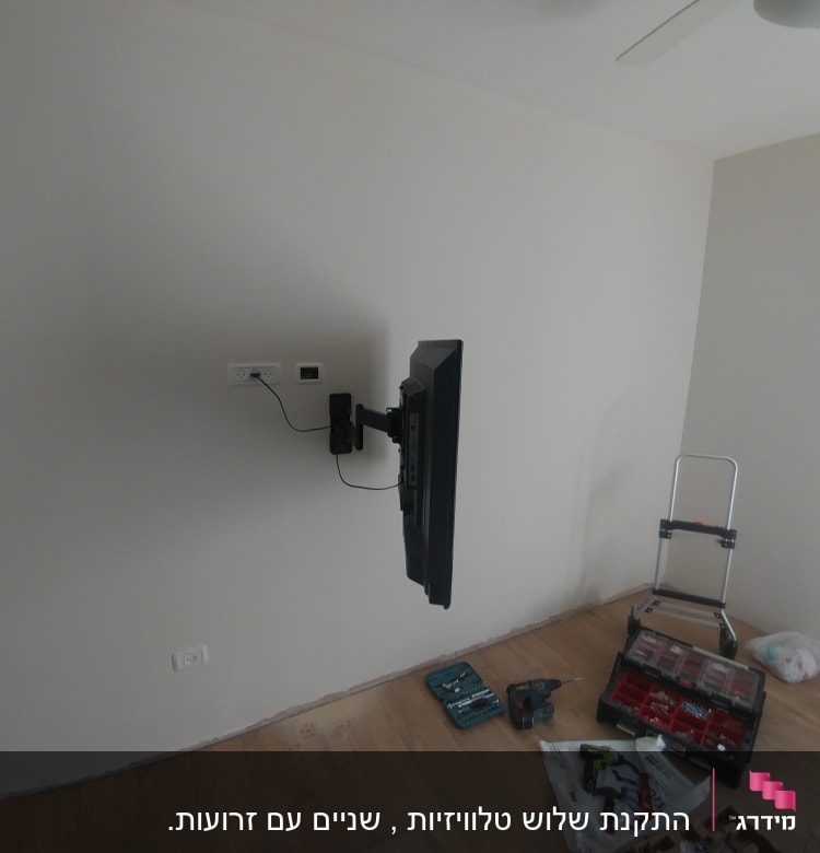 טלוויזיה מותקנת על קיר, כלי עבודה על הרצפה